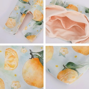 Detailed macro view of baby romper featuring fresh lemon and floral watercolor prints