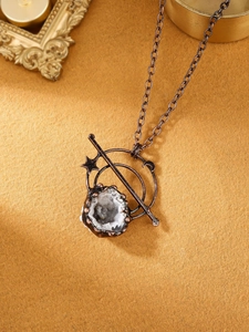 Detail van de vintage bronzen maanketting met witte kwartsgeode en kristallen sterren