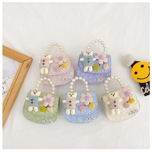 Detail of colorful children mini handbags with pearl handles and cute plush bear decors