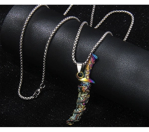 Macro shot of rainbow-colored dragon dagger pendant on black podium with steel chain