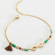 Detail of infinity charm necklace with green tube beads and a brown silk tassel charm