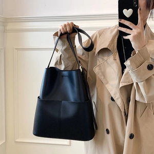 Detail einer minimalistischen schwarzen Eimer-Tasche aus Leder mit goldenen Elementen im Studio
