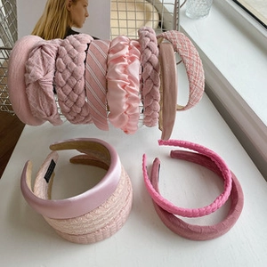 Detail of assorted pink headbands in satin, woven, and tweed fabrics on display