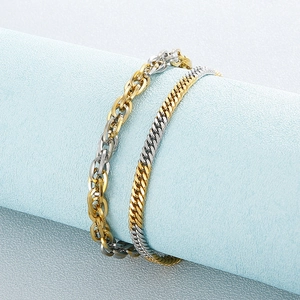Two-tone gold and silver titanium steel chain bracelet set on a cylindrical display stand