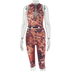 Detail of orange butterfly print halter crop top and cropped leggings set for women