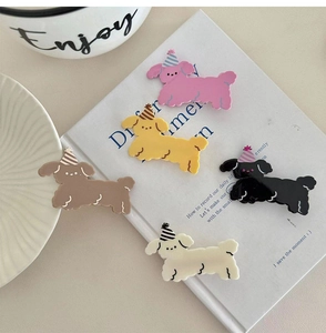 Close-up of adorable cartoon dog hair clips with striped party hats in five soft colors