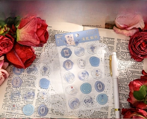 Detailed blue floral epoxy sticker with gold embossing on vintage book background
