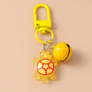Detail of yellow resin turtle keychain with matching bell and red shell pattern