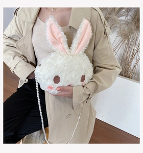 Close-up of cute white rabbit plush crossbody bag with elegant pearl chain strap