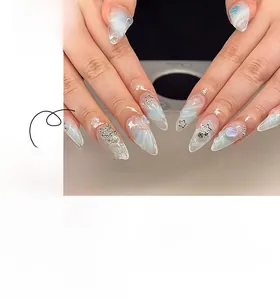 Detail of almond-shaped press-on nails with blue marble texture and 3D silver stars
