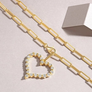 Gold heart pendant necklace with shimmering crystals on a stylish paperclip chain