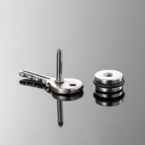 Unique stainless steel key stud earring for men and women on a reflective black surface