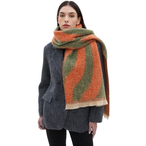 Thick orange and green striped bouclé knit scarf styled with a dark blazer coat