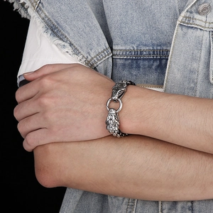 Detailed view of vintage silver snake-head buckle on a black braided rope bracelet