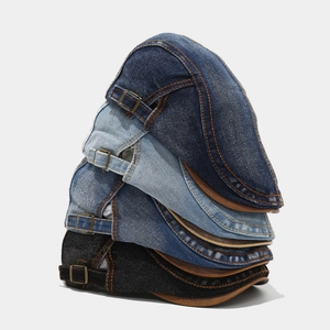 Stacked vintage denim flat caps in four colors with contrast stitching and metal buckles