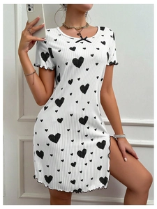 Détail de la robe blanche à motifs cœurs noirs, nœud au col et fente latérale sexy