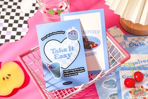 Detail of vintage postcards in a pink basket with decorative lifestyle accessories