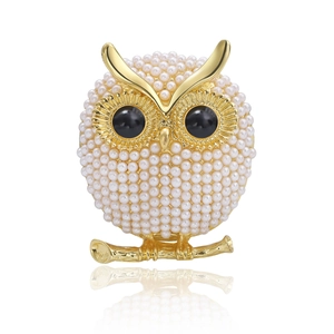 Golden owl brooch with milky faux pearls and black eyes perched on a branch