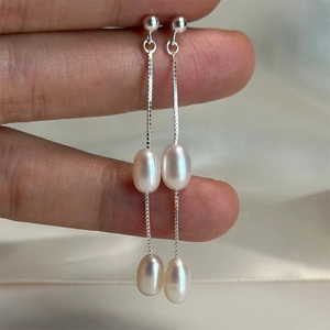 Elegant S925 silver long tassel earrings with lustrous freshwater pearls on silk background