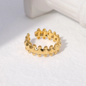 Detail of adjustable gold geometric spike ring on white marble surface with stone decor
