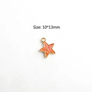 Close-up of pink star-shaped charm with gold plating and 10x13mm size measurement
