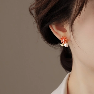 Gros plan de la boucle d'oreille fleur en cristal avec perle et papillon doré