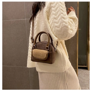 Detail of vintage brown suede crossbody bag with plush faux shearling pocket detail
