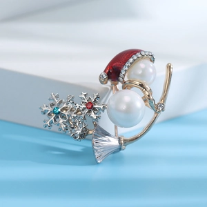 Detail of Christmas snowman brooch with pearls, snowflake motifs and festive red hat