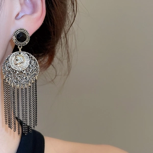 Macro detail of vintage coin tassel earrings featuring French Republic portrait design