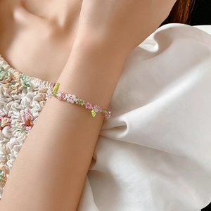 Close-up of handmade floral seed bead bracelet with pink and green translucent beads