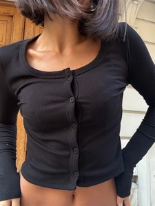 Close-up of black ribbed long-sleeve cropped cardigan with central button detailing