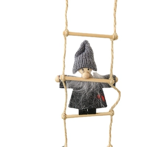 Handcrafted Christmas gnome with gray knit hat on a hemp rope ladder for holiday decor