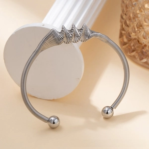Detail of silver twisted wire titanium steel cuff with modern wavy peak design