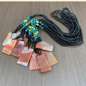 Detailed macro shot of natural agate rectangular pendants with layered silk textures