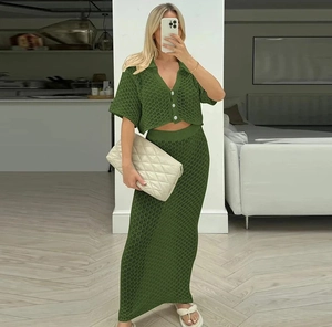 Dettaglio di completo a due pezzi in maglia verde con texture all'uncinetto e cardigan