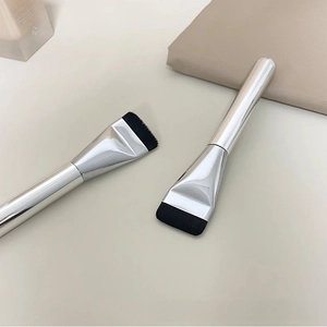 Macro shot of professional flat foundation brushes with silver handles and black bristles