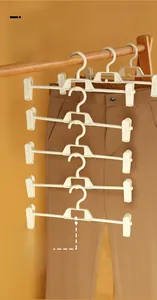 Detail of white multi-functional pants hanger with adjustable clips and bottom hooks