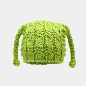 Detail of green cable knit trapper hat showing thick wool texture and earflaps