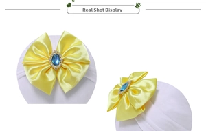Detail of baby turban with large yellow satin bow and blue gemstone rhinestone center