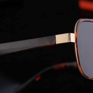 Detailed close-up of tortoise shell frame and gold metal hinges on stylish sunglasses