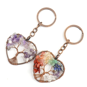 Detail of handmade bronze heart keychains with tree of life and colorful crystal stones