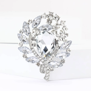 Macro shot of silver brooch with large teardrop crystal and leaf-shaped rhinestones