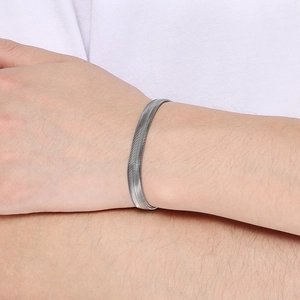 Close-up of a sleek silver herringbone snake chain bracelet on a person's wrist
