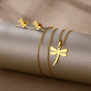 Golden dragonfly necklace and stud earrings set displayed on a silver jewelry holder