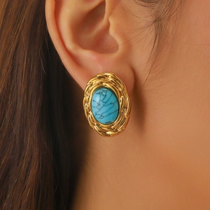 Vintage gold twisted rope earrings with oval turquoise stone worn by model