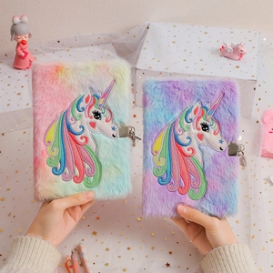 Detail of plush rainbow unicorn notebook featuring metallic lock and key mechanism