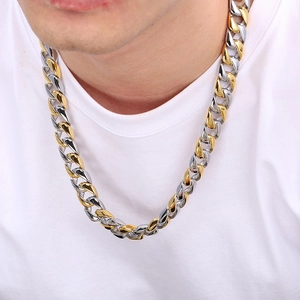 Detail of 15mm two-tone gold and silver Cuban chain necklace on a model neck