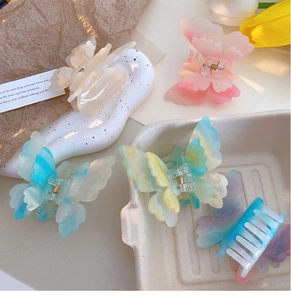 Detail of colorful gradient butterfly hair clips on a tray with tulips