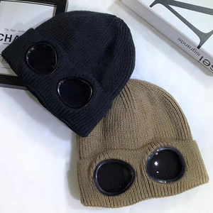 Detailed knit texture of ski beanies with signature built-in goggles in black and khaki