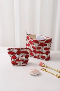 Detail of red mushroom jacquard fabric pouches in large and small drawstring sizes